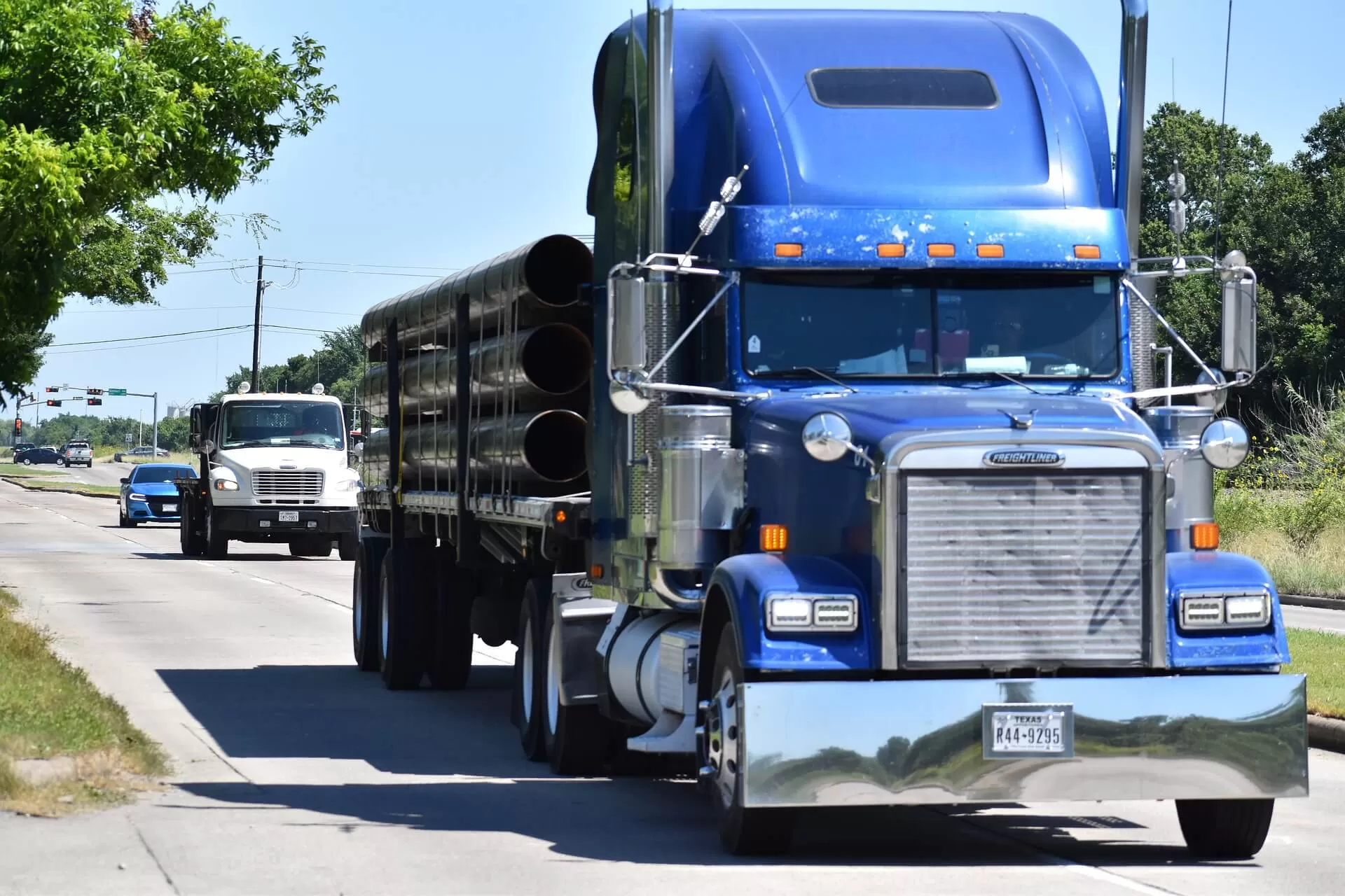 Blue Freightliner truck loaded with pipes
