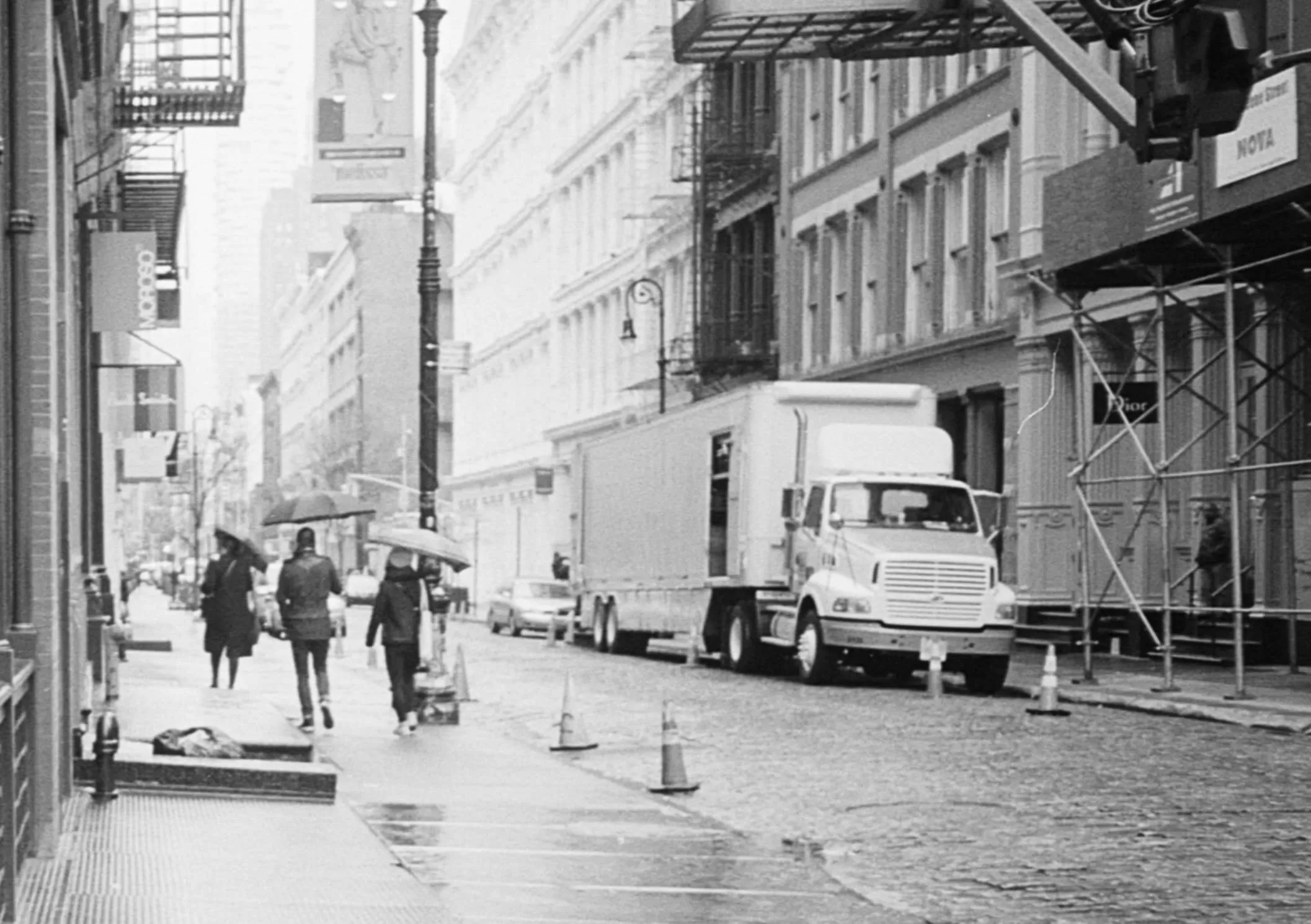 An old grayscale photo shows a truck on the street of a city