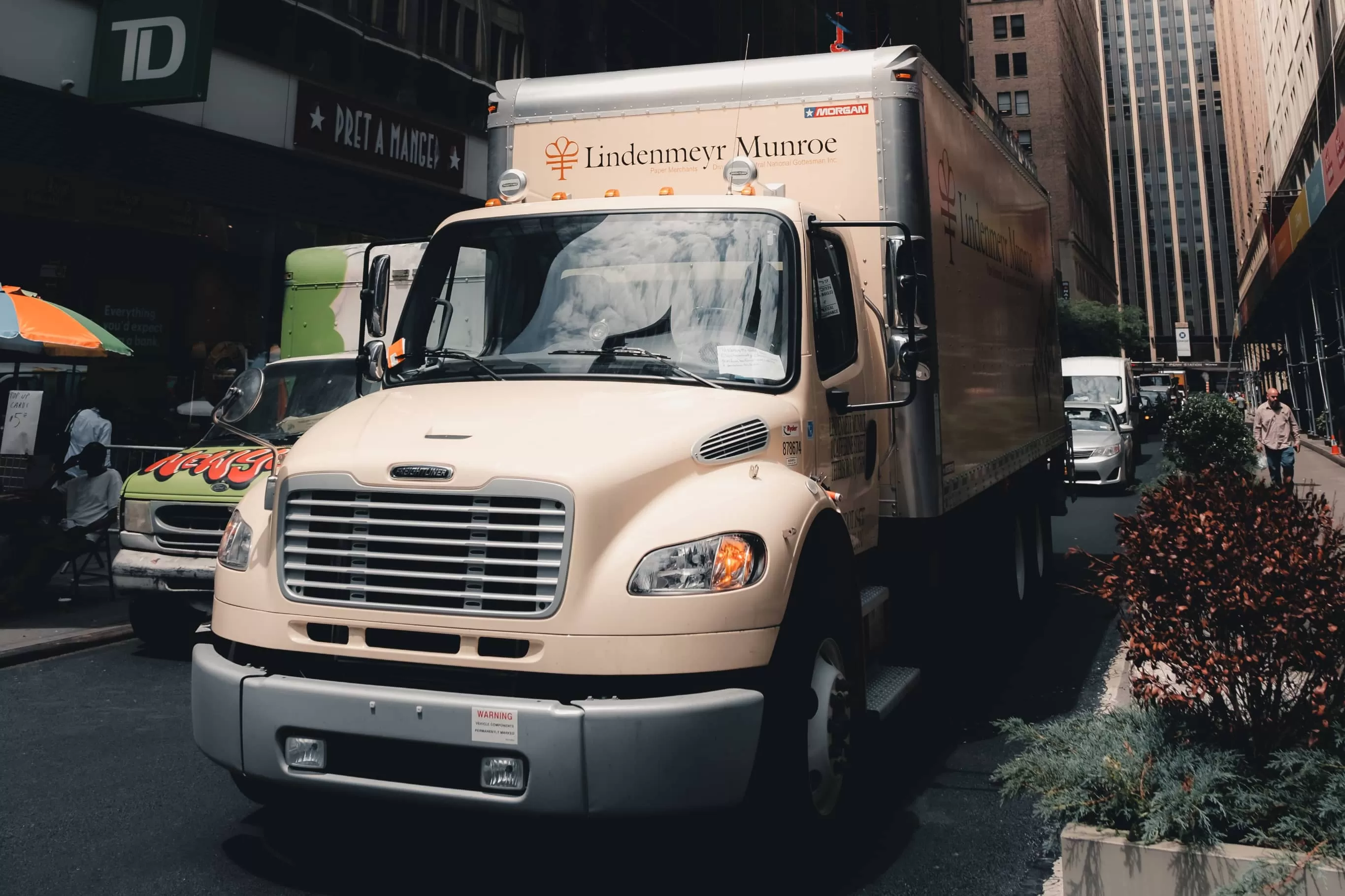 Beige Freightliner truck on the street