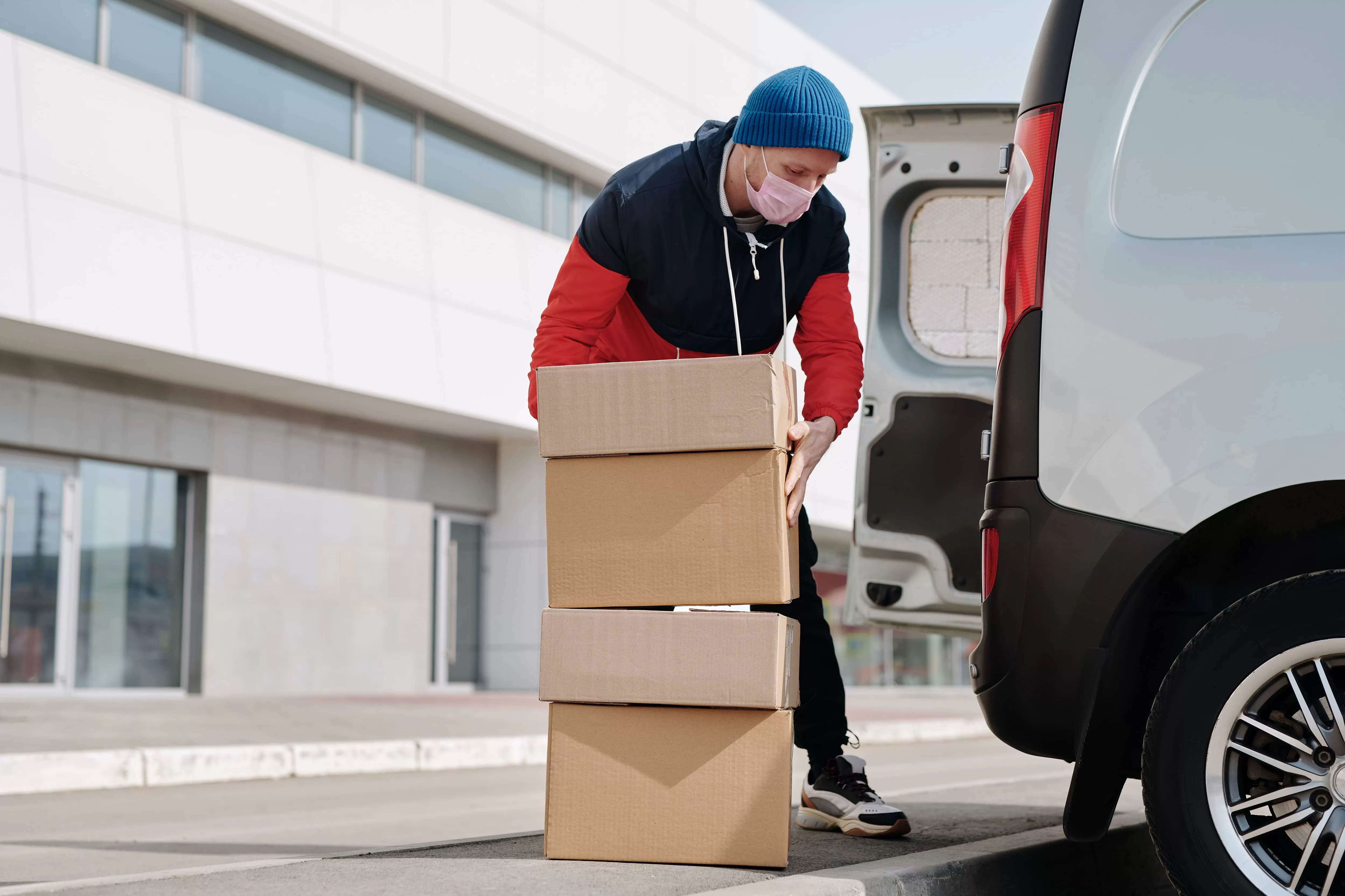 A man loads packages into the delivery car.