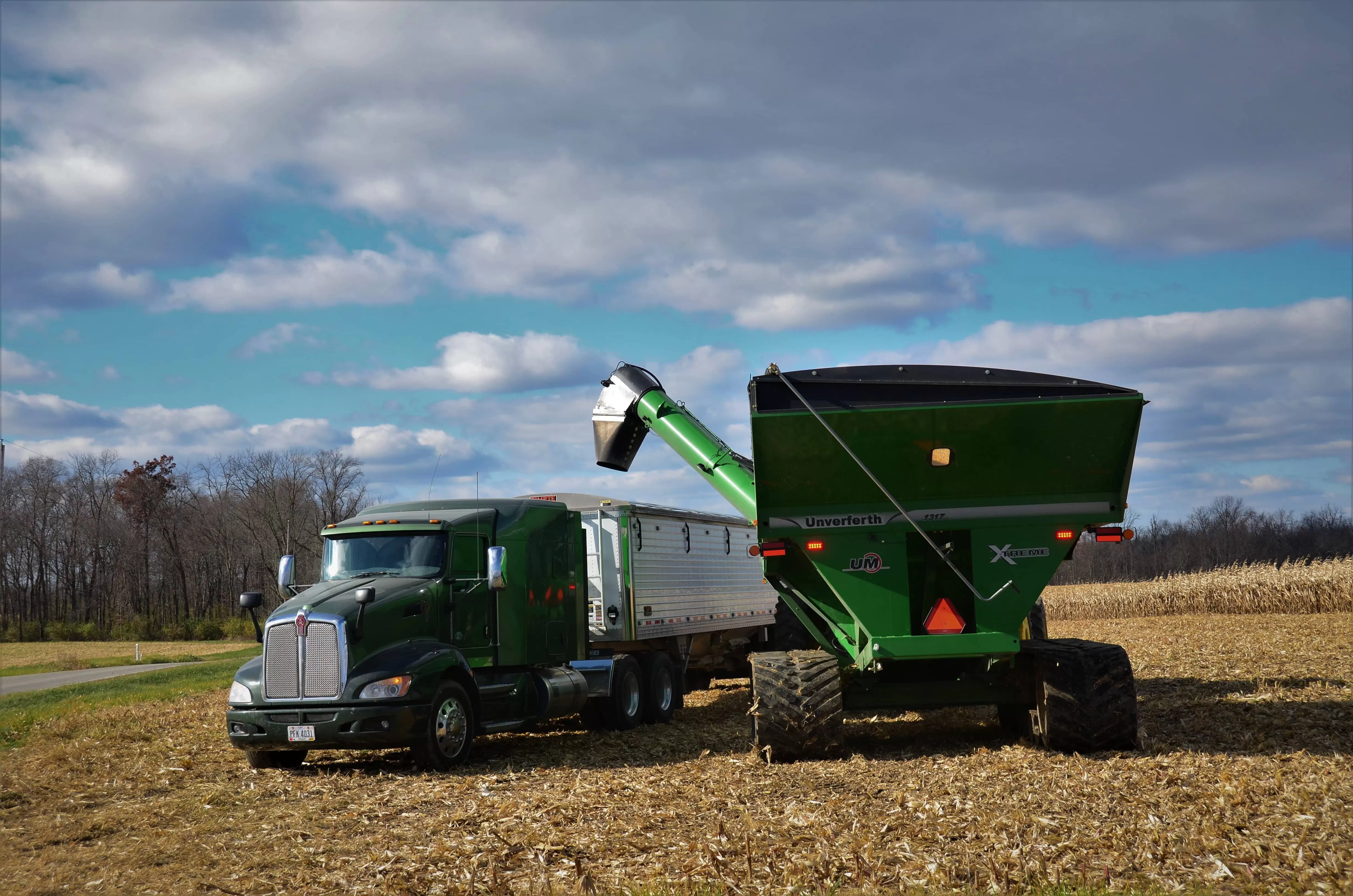 Green truck loads on field