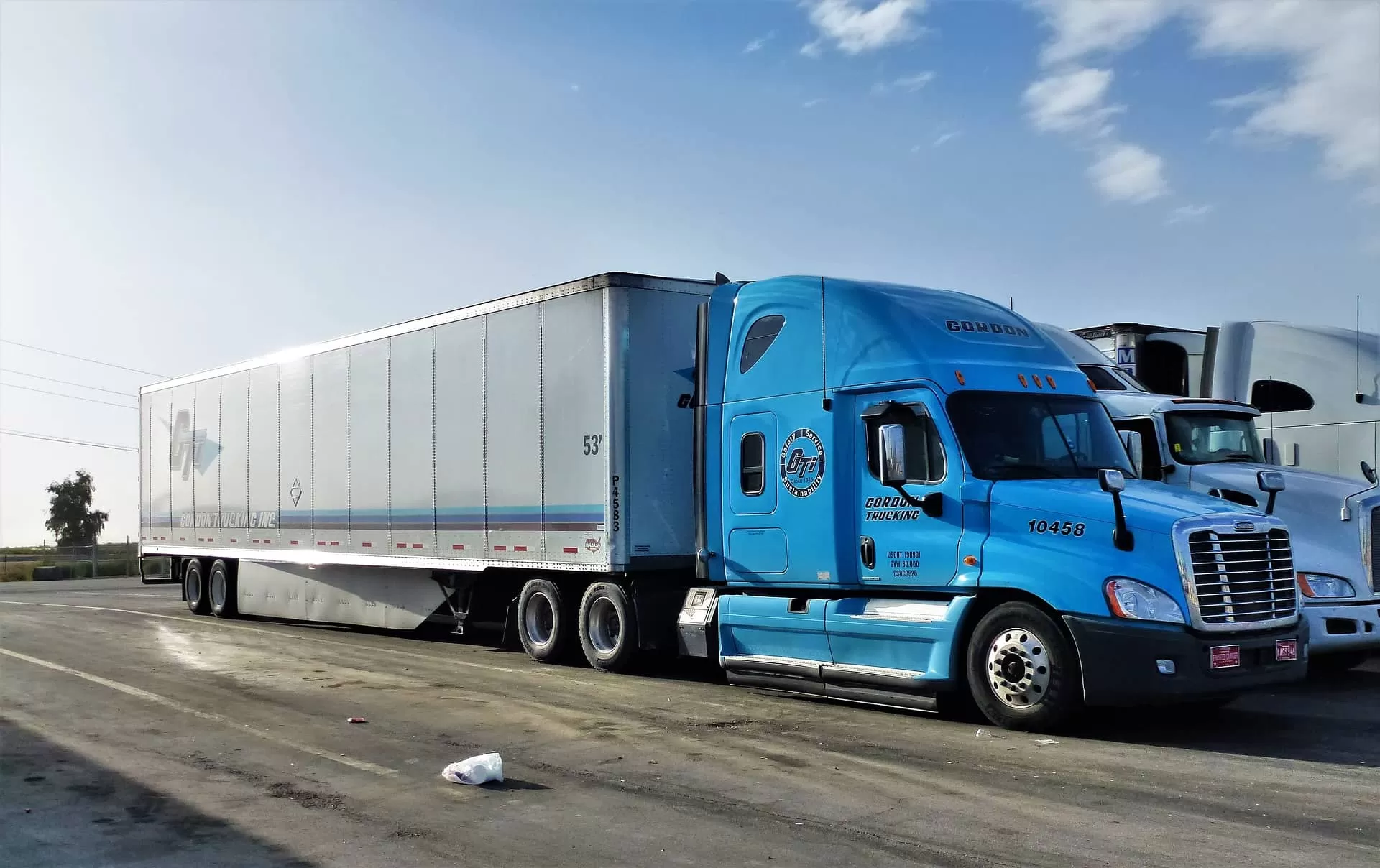 blue freightliner truck with trailer on the truck parking