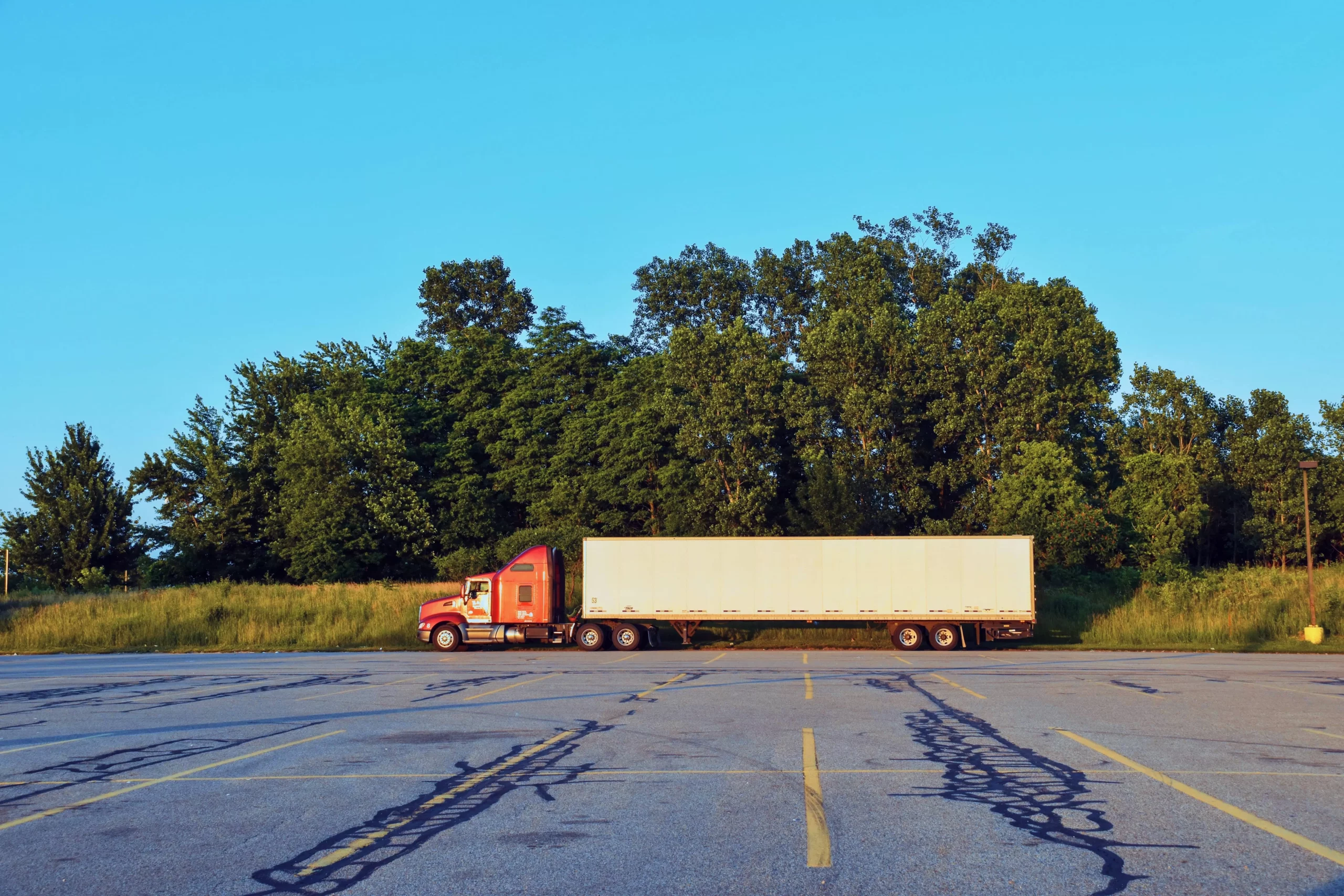 red truck with trainer on empty truck parking scaled