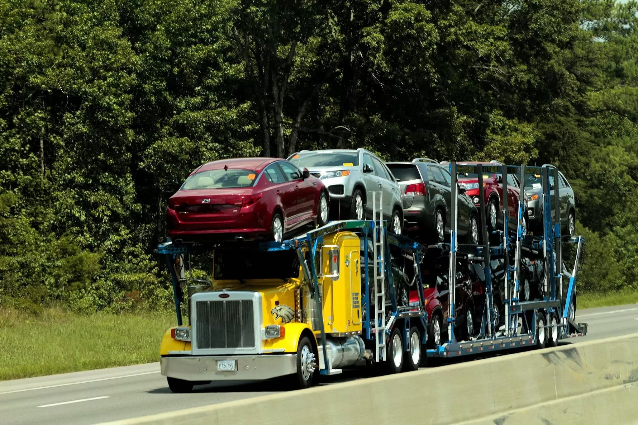 yellow car hauler loaded with cars